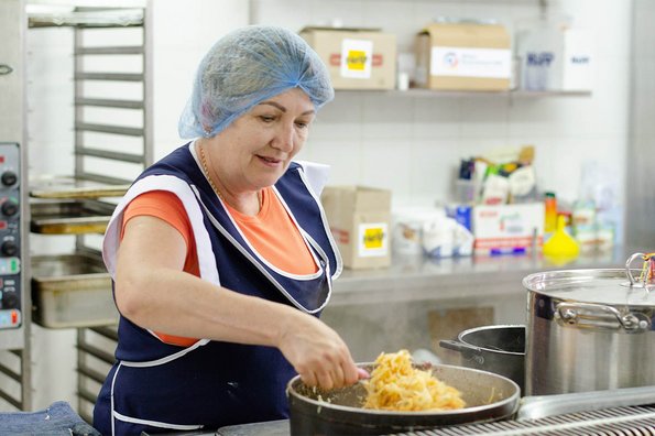 Eine Frau bereitet Essen für vertriebene ukrainische Familien vor