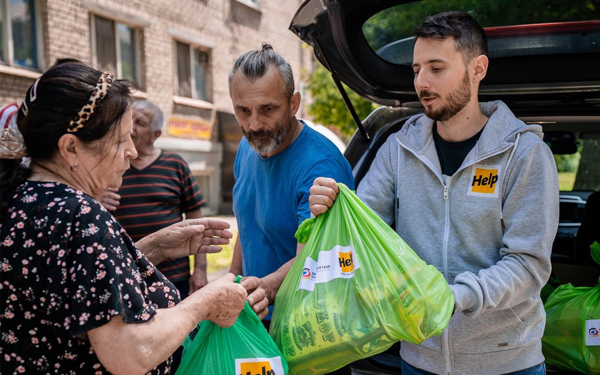 Mitarbeiter von Help übergeben Hilfsgüter an eine ukrainische Frau